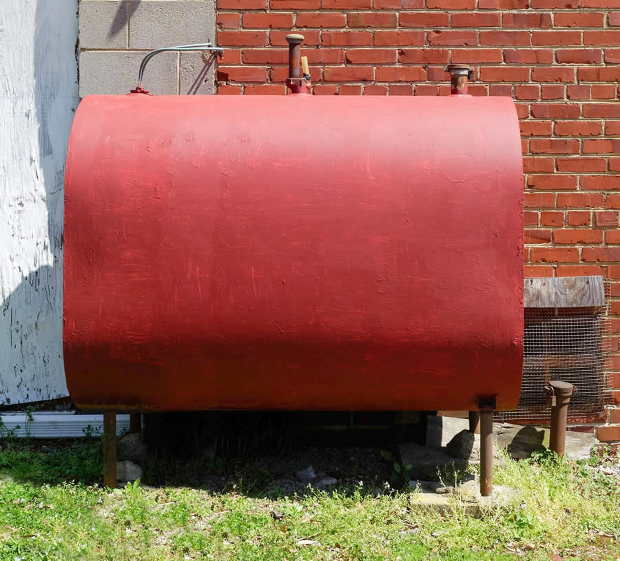 Red old oil tank outside of home